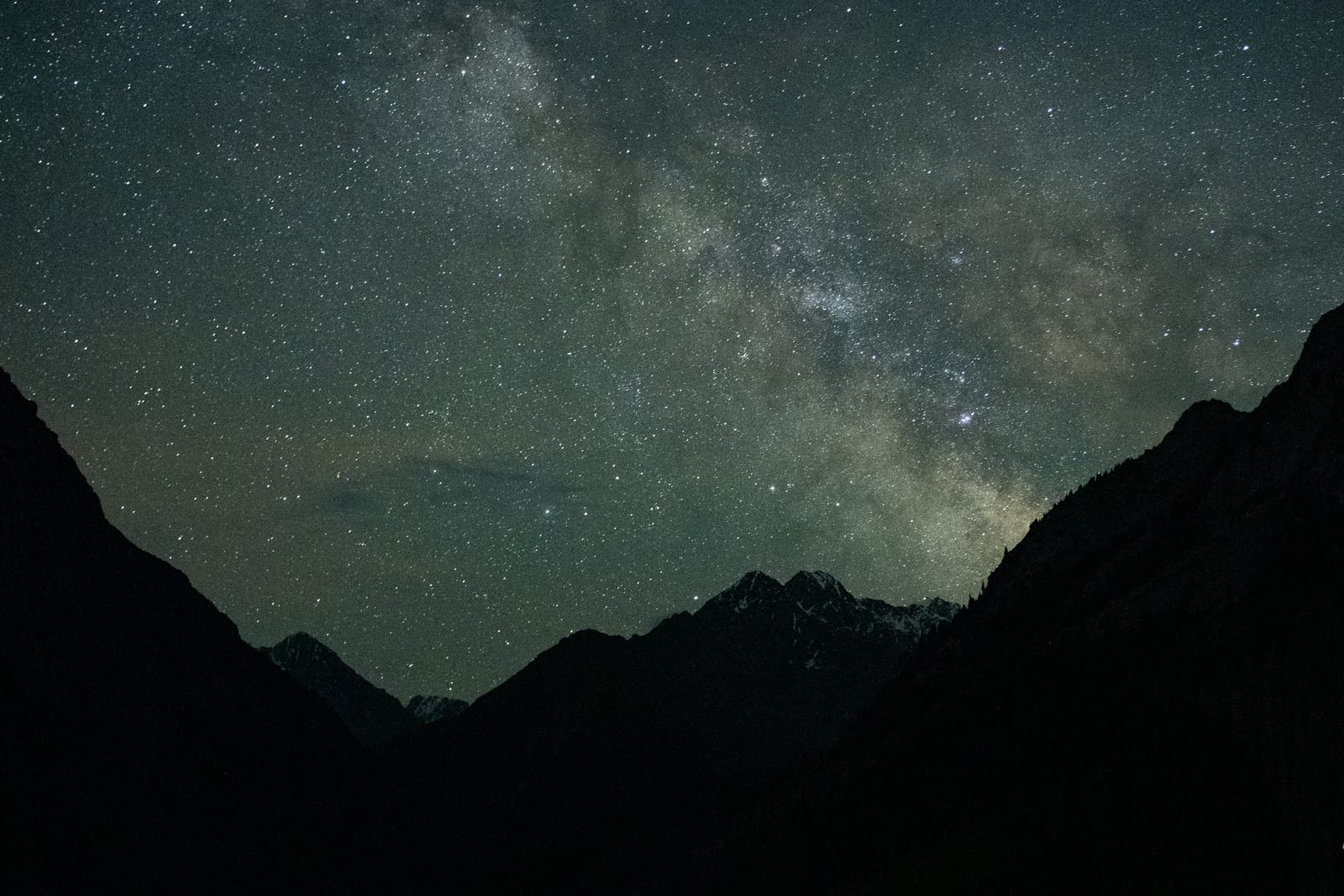 Milky Way over the silhouetted V of a mountain valley