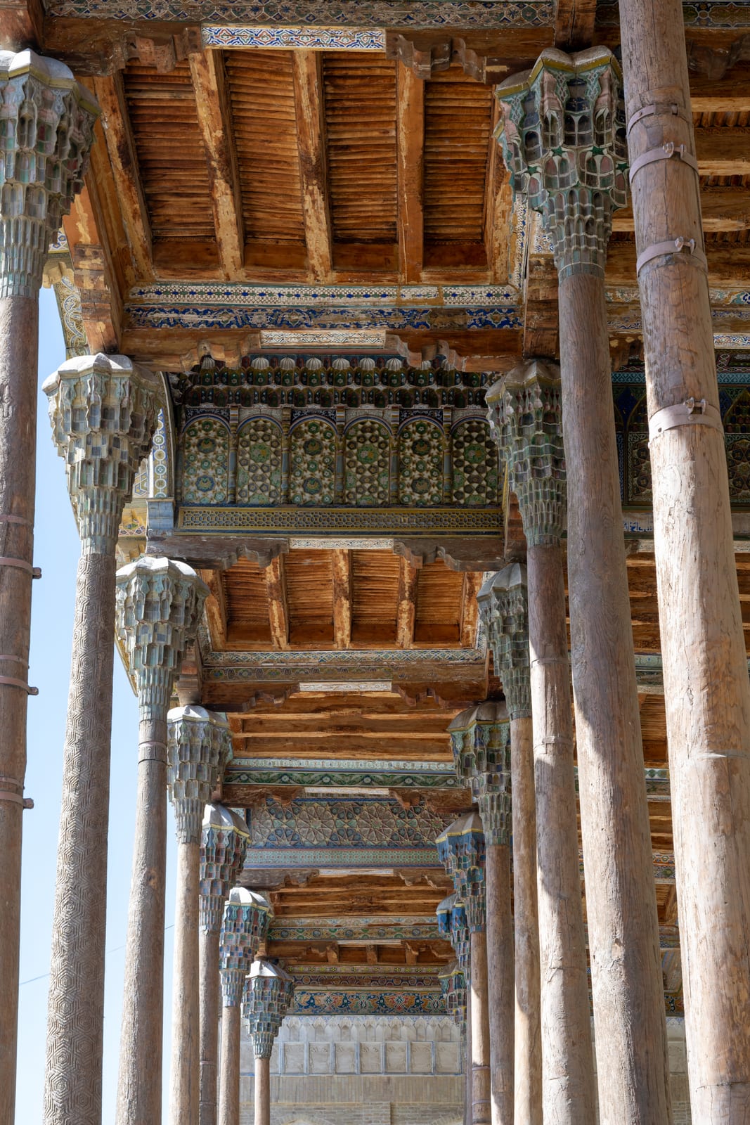 Receding rows of carved wooden columns under a painted timber ceiling