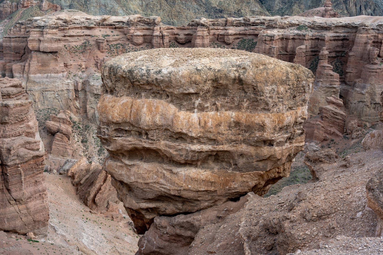 Large layered sandstone boulder balanced above the canyon