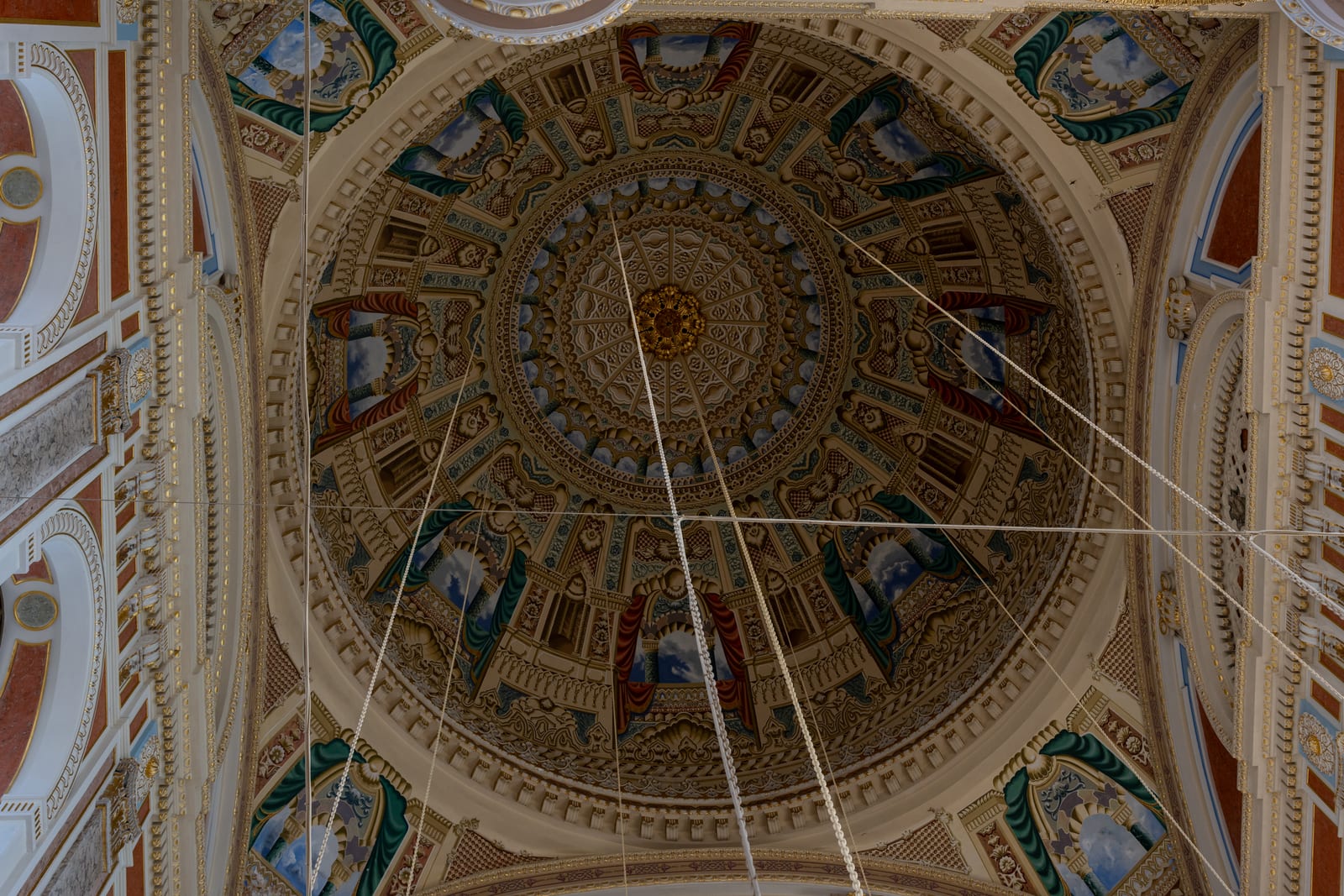 Looking straight up into the ornate painted and gilded dome of a baroque mosque