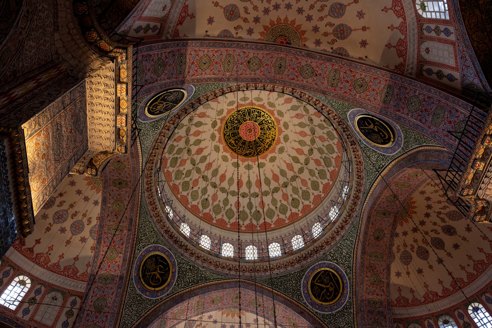 Red, green and gold painted domes and semi-domes of the New Mosque seen from below