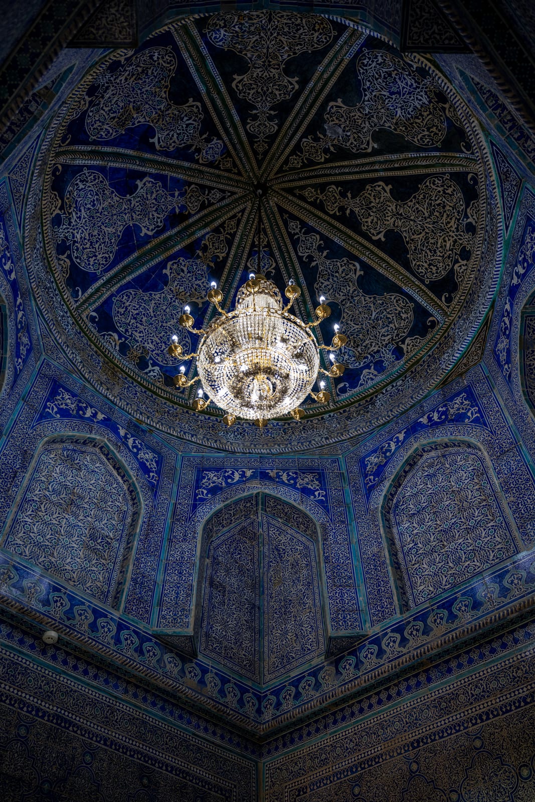 Deep blue tiled dome ceiling with a crystal chandelier at its centre