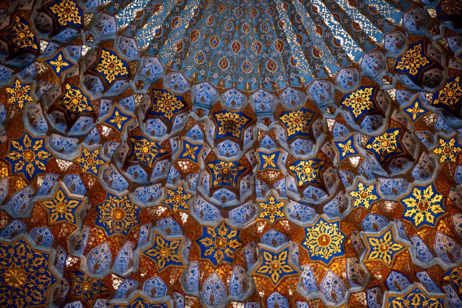 Gold and blue star-patterned muqarnas ceiling in close view