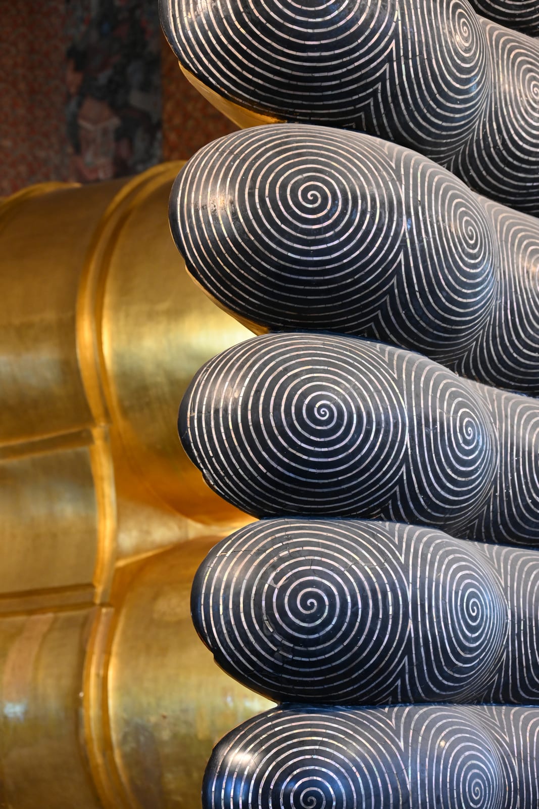 Toes of the Reclining Buddha with spiral inlay, gold and dark tones