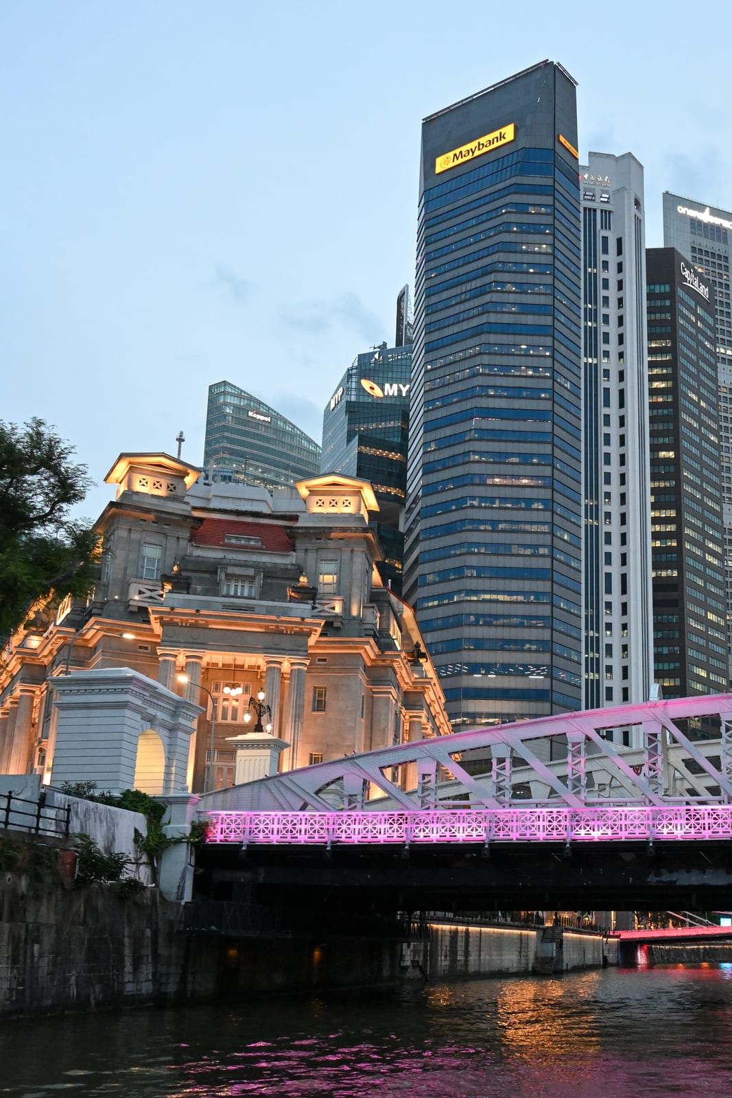 Fullerton Hotel and pink-lit bridge beneath downtown towers at twilight