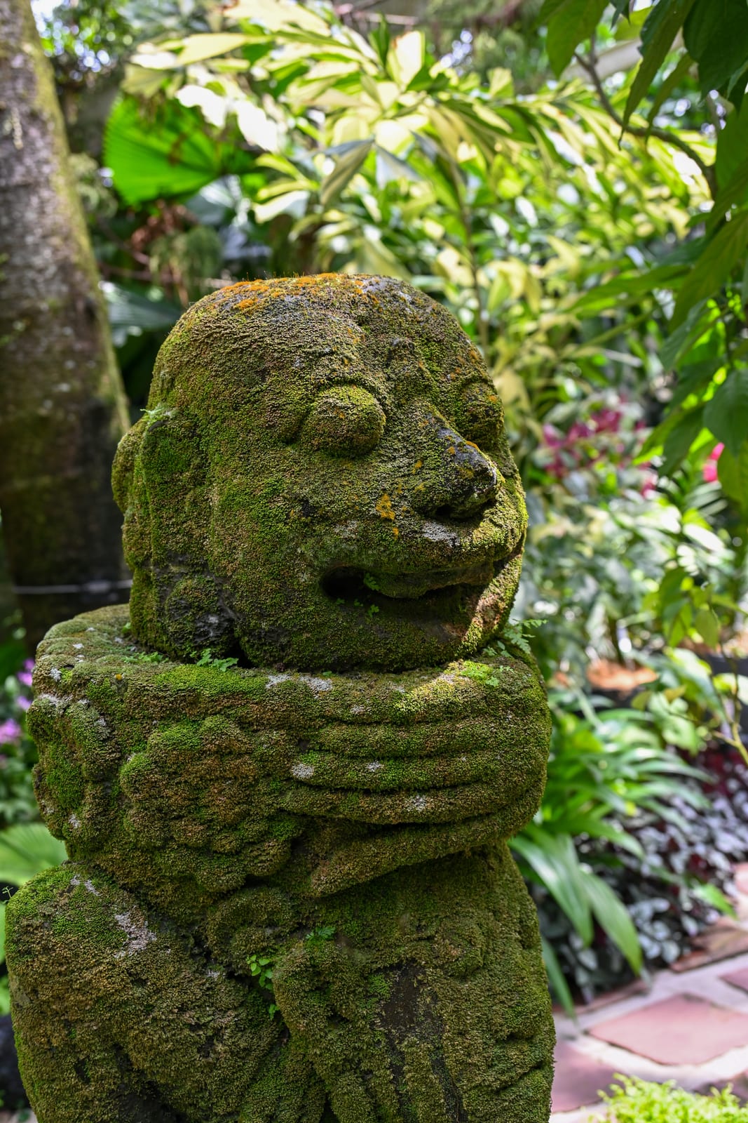 Moss-covered stone figure in a lush garden