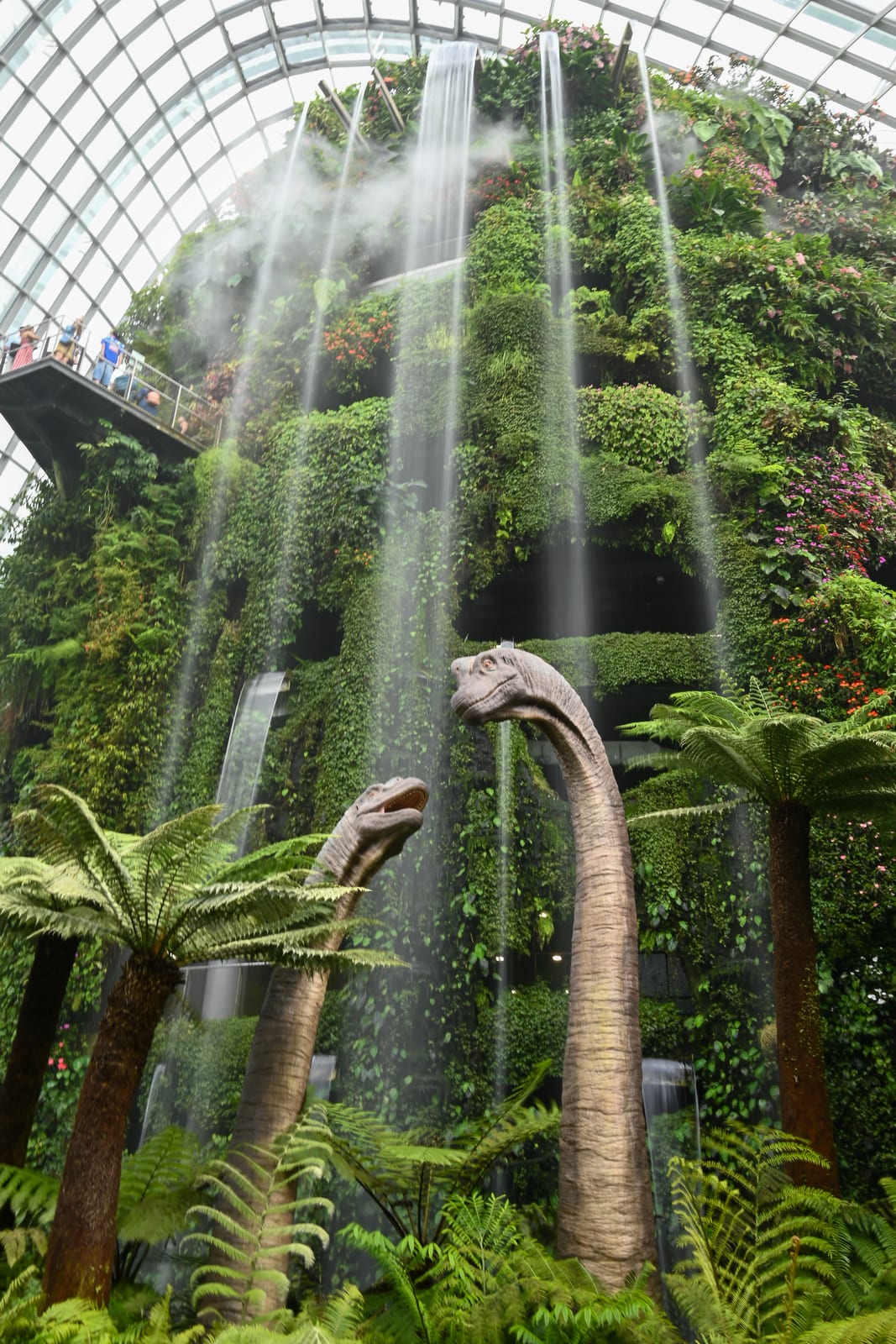 Cloud Forest indoor waterfall and green mountain with dinosaur sculptures