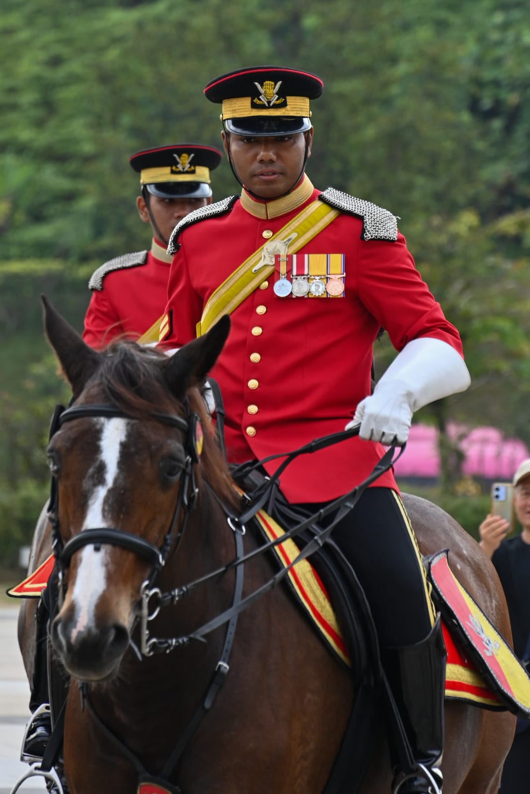 Mounted royal guard in red uniform on a brown horse