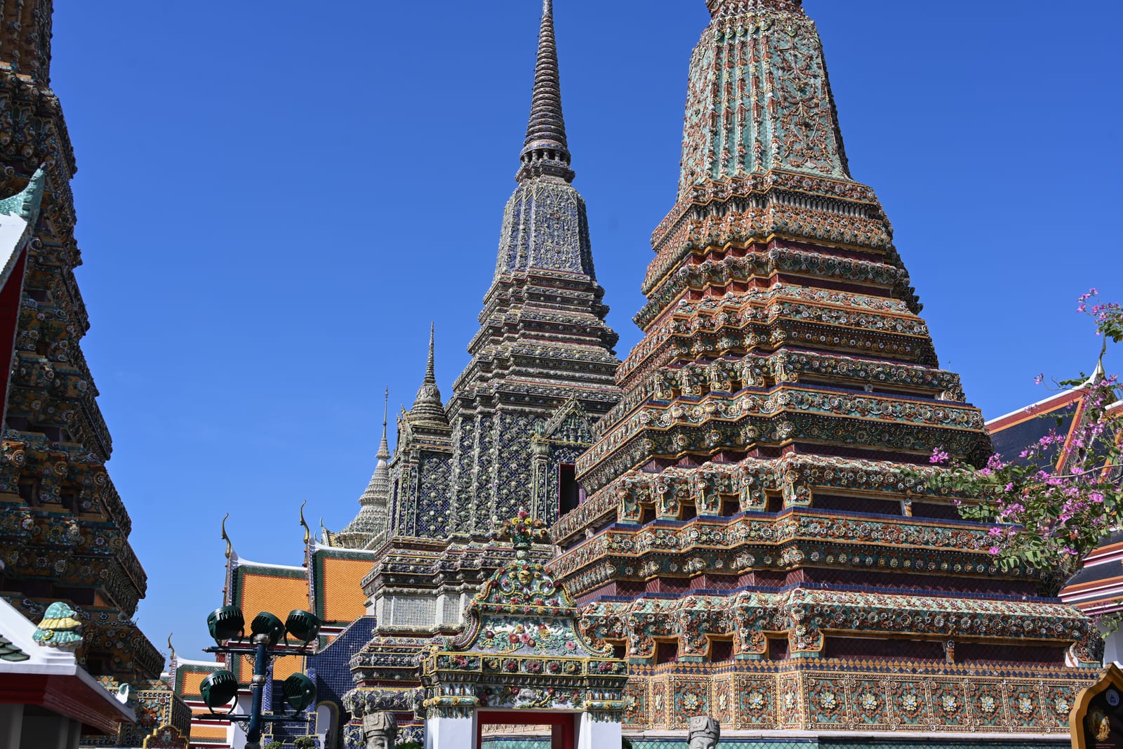 Cluster of tiled chedis at Wat Pho under a clear blue sky